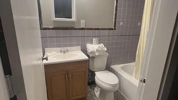 A bathroom with a toilet, sink, and bathtub.