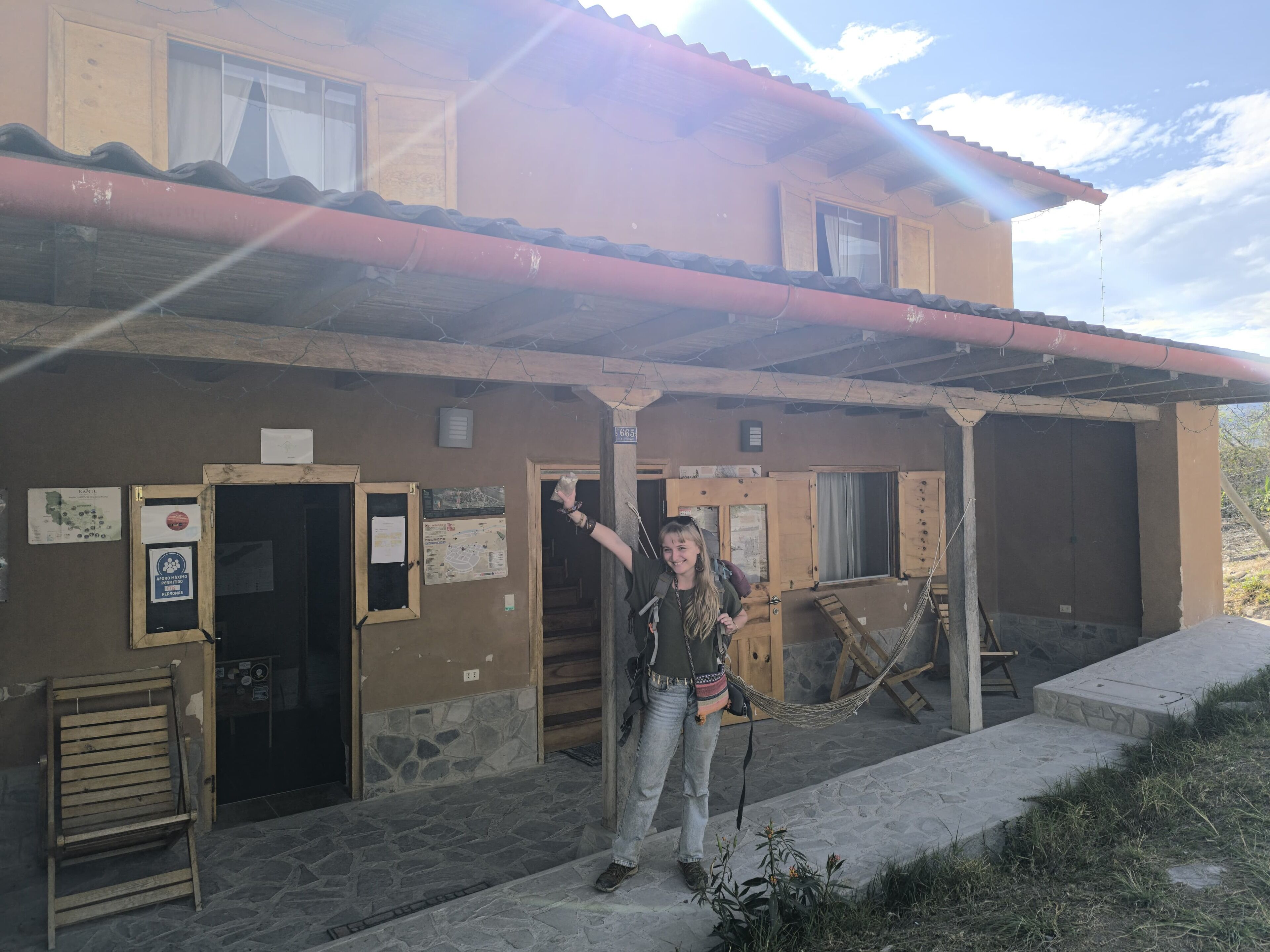 A building with multiple doors, a wooden bench, and a hammock.