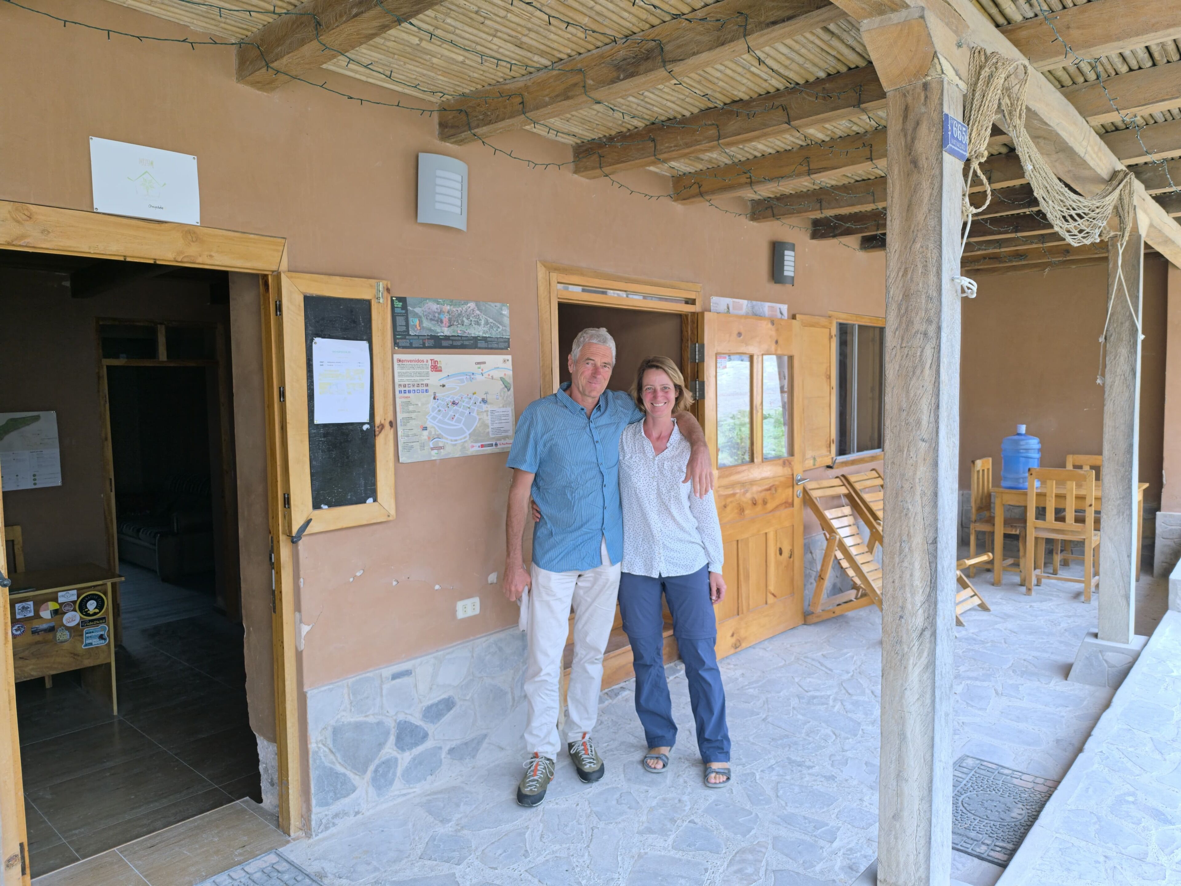 Ein Holzhaus mit Steinboden, einer Holztür und einem Schild an der Wand.