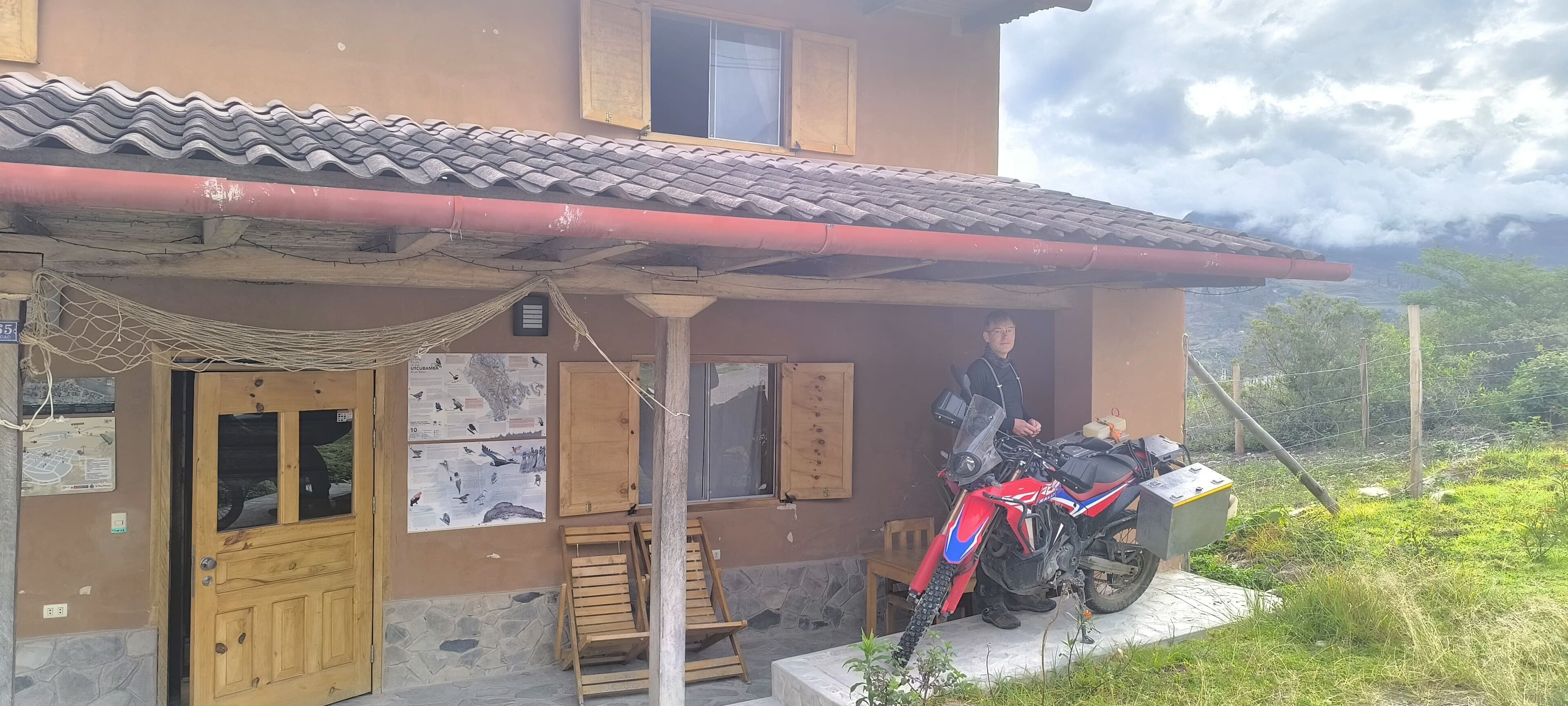 A house with a tiled roof, a wooden door, and a motorcycle parked outside.