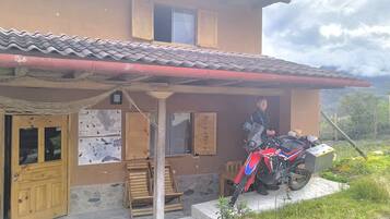 A house with a tiled roof, a wooden door, and a motorcycle parked outside.