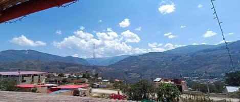 A mountainous landscape with a clear sky and scattered clouds.