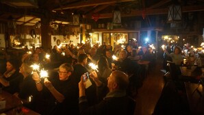 A crowded indoor space with wooden beams and hanging lanterns. - Wiesengrund (Bad Hindelang)