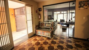 A hotel lobby with a check-in counter, a fire extinguisher, and a large window offering a view of the outside. - Zen Garden Hostel (São Paulo)