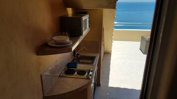 Condo panorámico, 1 cama King size, Terraza, vista al océano | Cocineta privada | Refrigerador, microondas, parrilla de estufa y cafetera y tetera