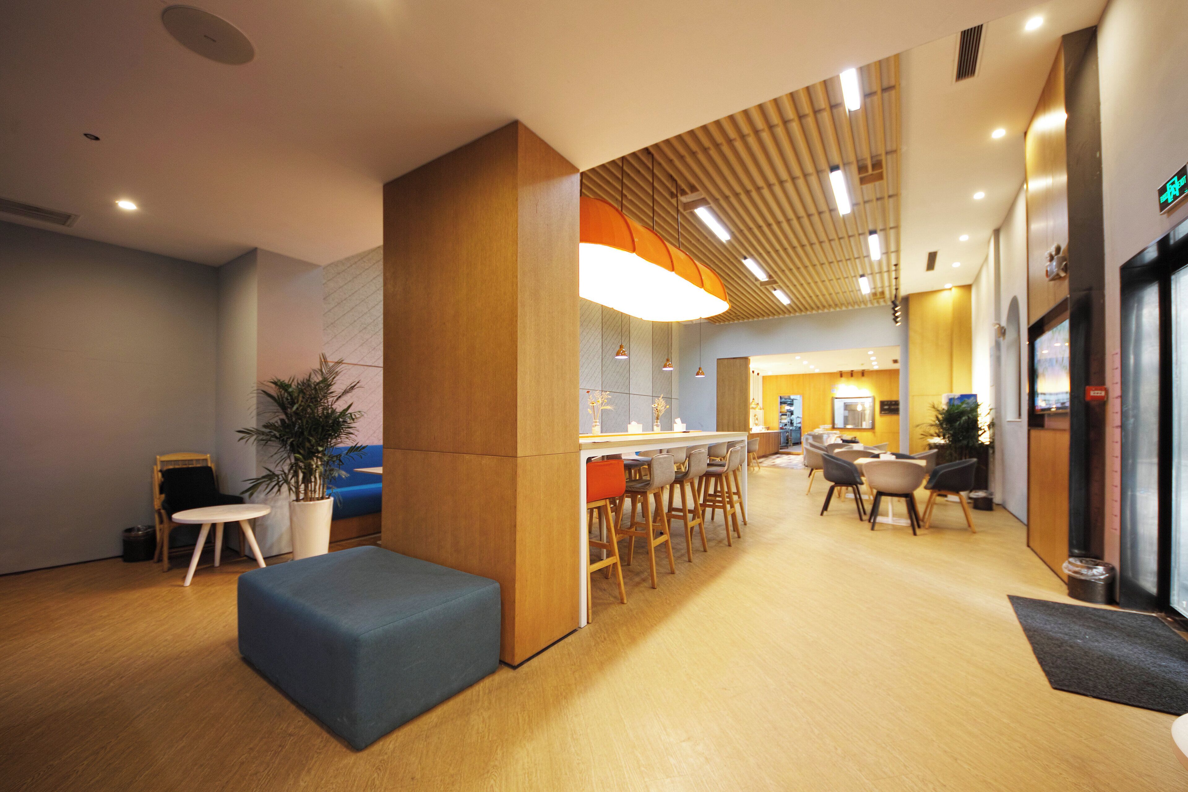 Een modern interieur met een receptiebalie, zithoek en een bar.