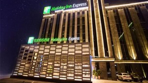 A Holiday Inn Express hotel with a modern facade, large windows, and a prominent sign.