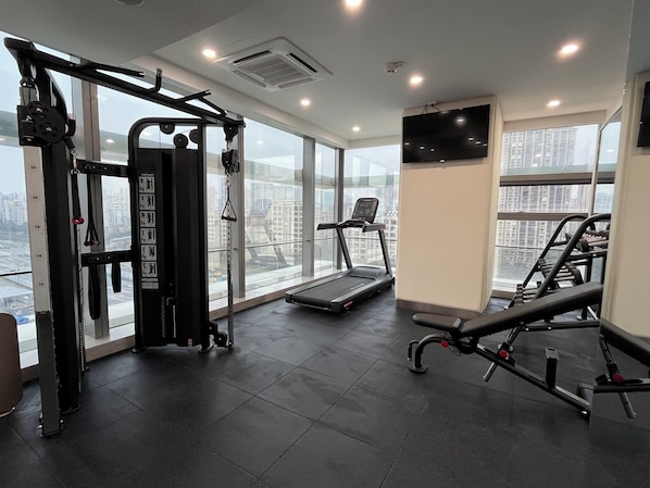 A gym with a treadmill, weight machines, and a bench press. - Holiday Inn Express Suzhou Industrial Park by IHG (Suzhou)