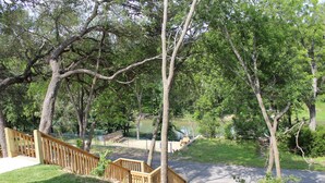 Un parc doté d’un escalier en bois menant à une plateforme d’observation, entouré d’arbres et bordé d’une étendue d’eau.