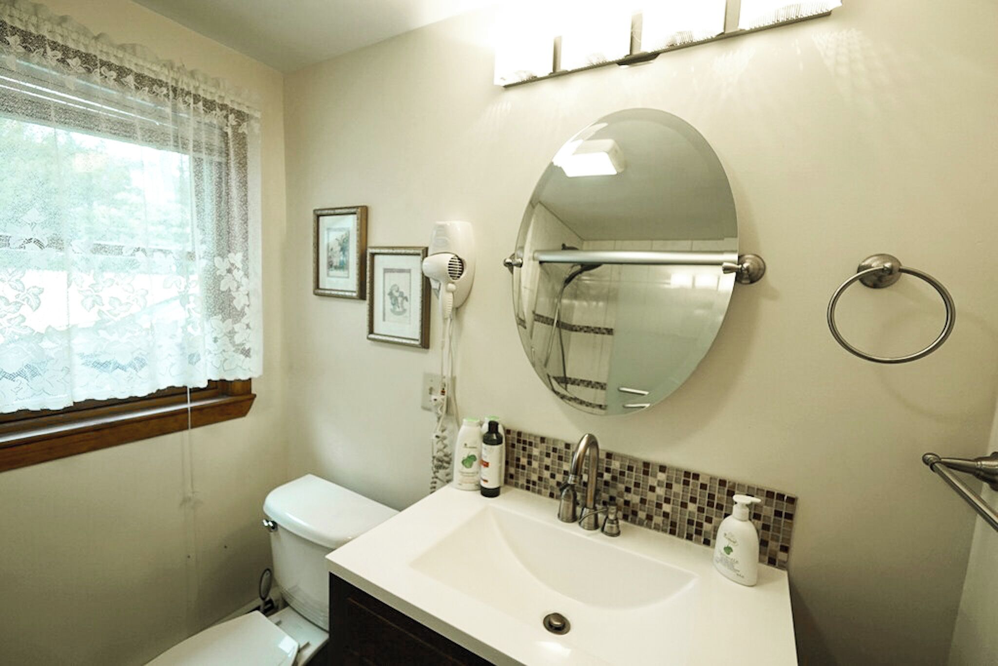 Ein Badezimmer mit Toilette, Waschbecken, Spiegel und Dusche.