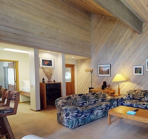 A living room with a sofa, a coffee table, a fireplace, and framed pictures on the wall.