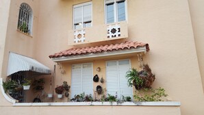 A building with a balcony, white shutters, and a tiled roof. - Apex living in Puerto Rico's capital  (Santurce)