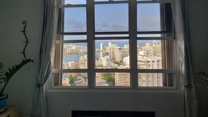 A window with a view of a cityscape and a body of water. - Apex living in Puerto Rico's capital  (Santurce)