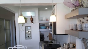 A modern kitchen with two pendant lights, a coffee machine, and a sink. - Apex living in Puerto Rico's capital  (Santurce)