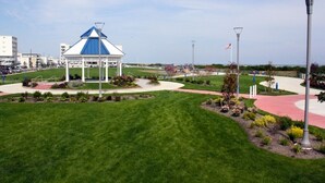 A gazebo with a blue roof, surrounded by a landscaped garden with pathways and benches.