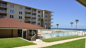Un hotel su più piani con piscina, un patio coperto e vista sull'oceano.