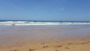 Uma praia com céu limpo e ondas calmas.