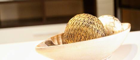 A bowl with two decorative items on a white surface.