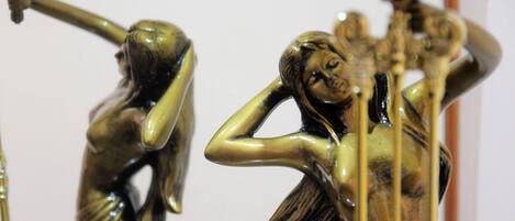 En bronzeskulptur af en kvinde med en spejlenende overflade, placeret på et stativ.