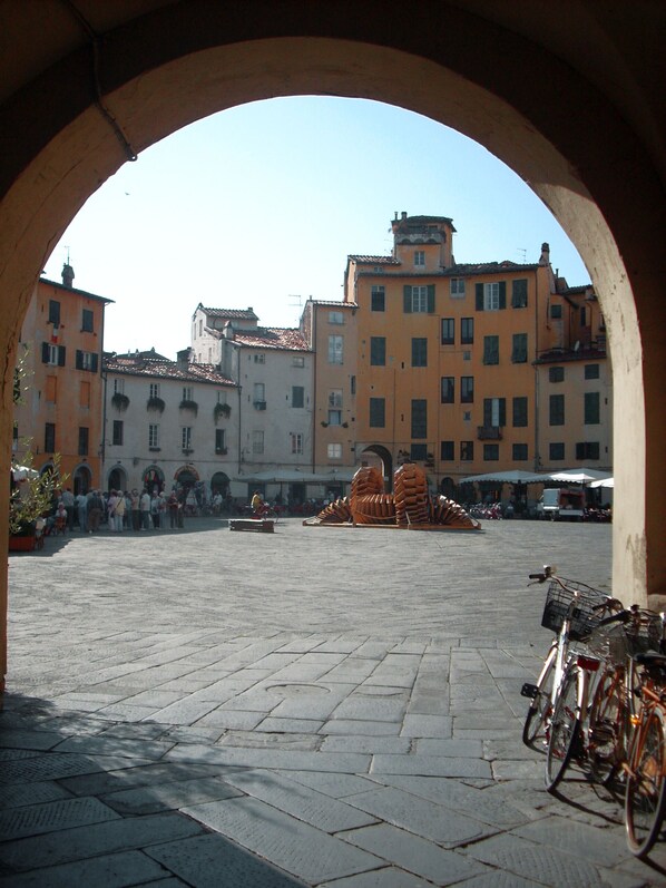 An open square with a fountain, historic buildings, and bicycles parked.
