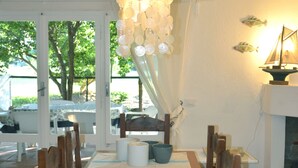 Et spiseområde med et træbord, stole, en hængende lampe og en pejs.