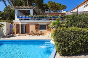 A two-story house with a swimming pool, outdoor seating, and potted plants. - Front-Line Sea Villa In Mallorca. Up to 6 Guests (Capdepera)