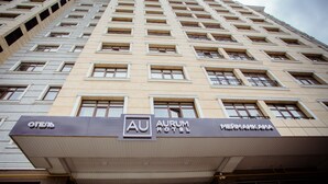 A hotel building with multiple floors, a prominent sign for "AURUM HOTEL," and several windows with balconies. - Aurum Hotel (Bishkek)