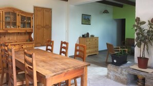 Comedor con una mesa y sillas de madera, un armario de madera y una pared verde.