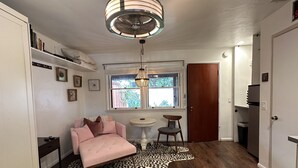 Un salon chaleureux avec un canapé rose, une petite table ronde et un tapis à motifs léopard.