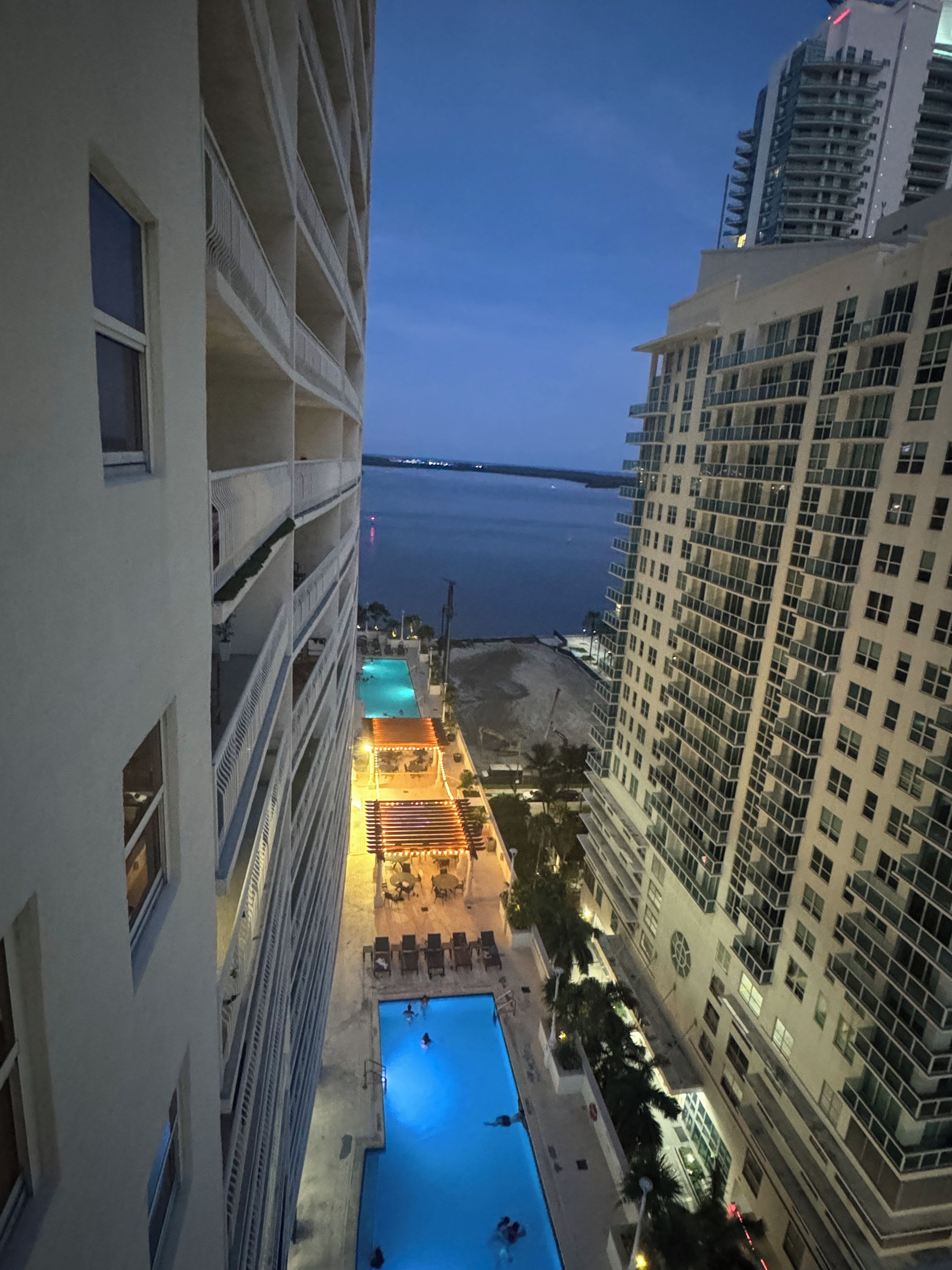 A high-rise building with a swimming pool and outdoor seating area.