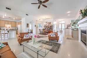 A spacious living area with a glass coffee table, leather sofas, and a fireplace. - Magical Getaway: Garden Oasis & Pool, Golfing, Hiking,Special Discounts. (Las Vegas)