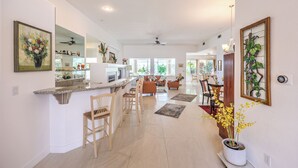 A spacious kitchen with a bar area, wooden chairs, and a dining area with a view. - Magical Getaway: Garden Oasis & Pool, Golfing, Hiking,Special Discounts. (Las Vegas)