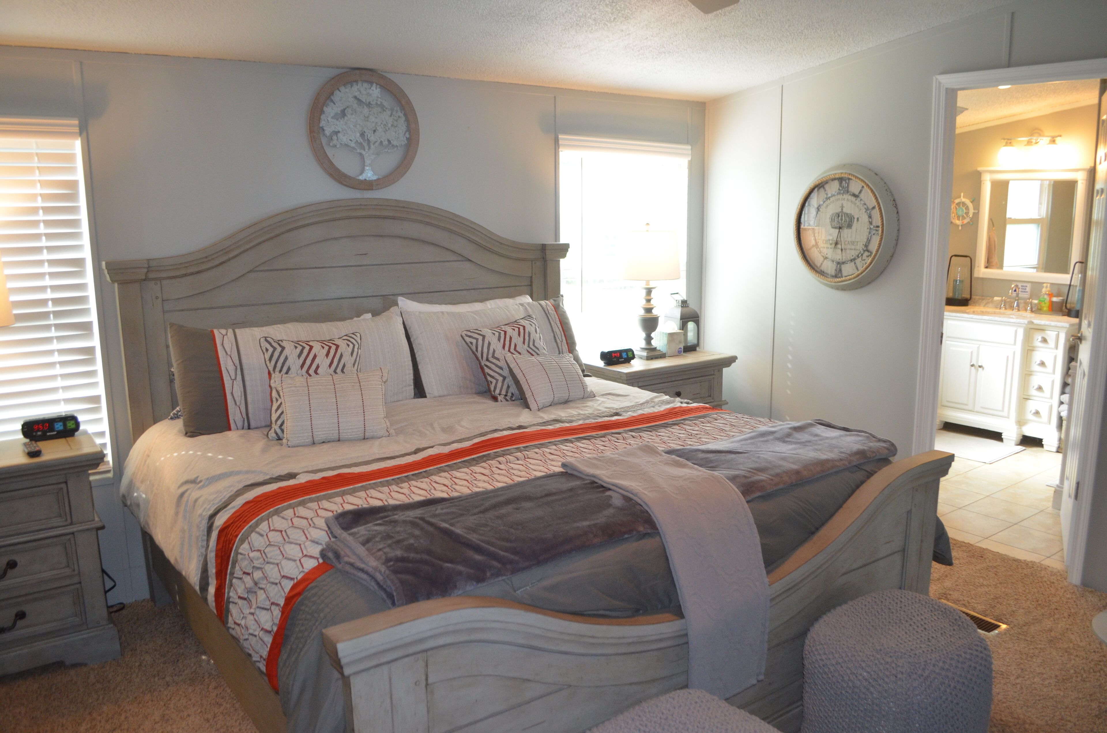 Een slaapkamer met een bed, nachtkastjes, een dressoir en een spiegel.