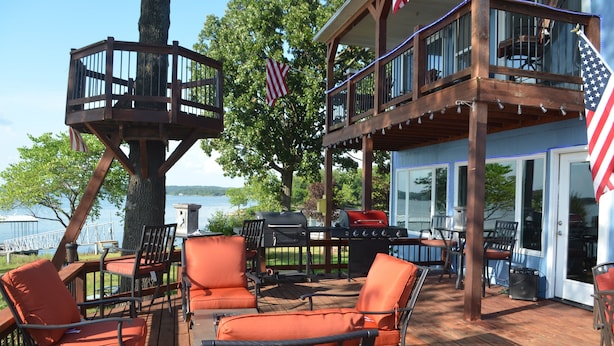 A deck with outdoor furniture and a barbecue area, overlooking a body of water. - GRAND PANORAMIC RETREAT, 6 BR, 3 BA, 300' Lakefront, Dock & Launch! NEW (Grove)