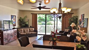A spacious living area with a dining table, sofa, and chairs, a ceiling fan, and a chandelier. - 2/2 BEACH FRONT RESORT-AC-Poipu Bch, Kiahuna-Garden View, Pool/Gym/Courts (Poipu Beach)