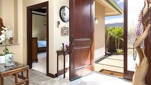 A room with a wooden door leading to a balcony with a view of the mountains. - BIG ISLAND PARADISE-private lanai -pool/spa/low golf rates/access to #1 beaches  (Kamuela)