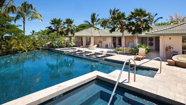 A pool area with lounge chairs, palm trees, and a building with a tiled roof. - BIG ISLAND PARADISE-private lanai -pool/spa/low golf rates/access to #1 beaches  (Kamuela)