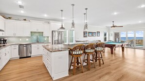 A spacious kitchen with white cabinets, a stainless steel dishwasher, and a pool table. - Cape Conchs: Large Beachfront Home, Private Pool, Sleeps 18, Pet Friendly (Cape San Blas)