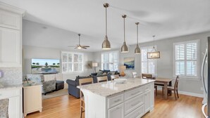 A spacious kitchen with a large island, white cabinetry, and pendant lighting. - Award-Winning Resort Amenities | Back Bay 5813 (Isle Of Palms)