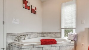 A bathroom with a marble sink, a red bath mat, and a window with blinds. - Romantic Lakeview Treehouse with Private Jacuzzi (Stigler)