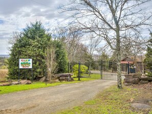 A gated entrance to a property with a sign indicating 'CALIGO THE HILLS SOUTH'. - Romantic Lakeview Treehouse with Private Jacuzzi (Stigler)