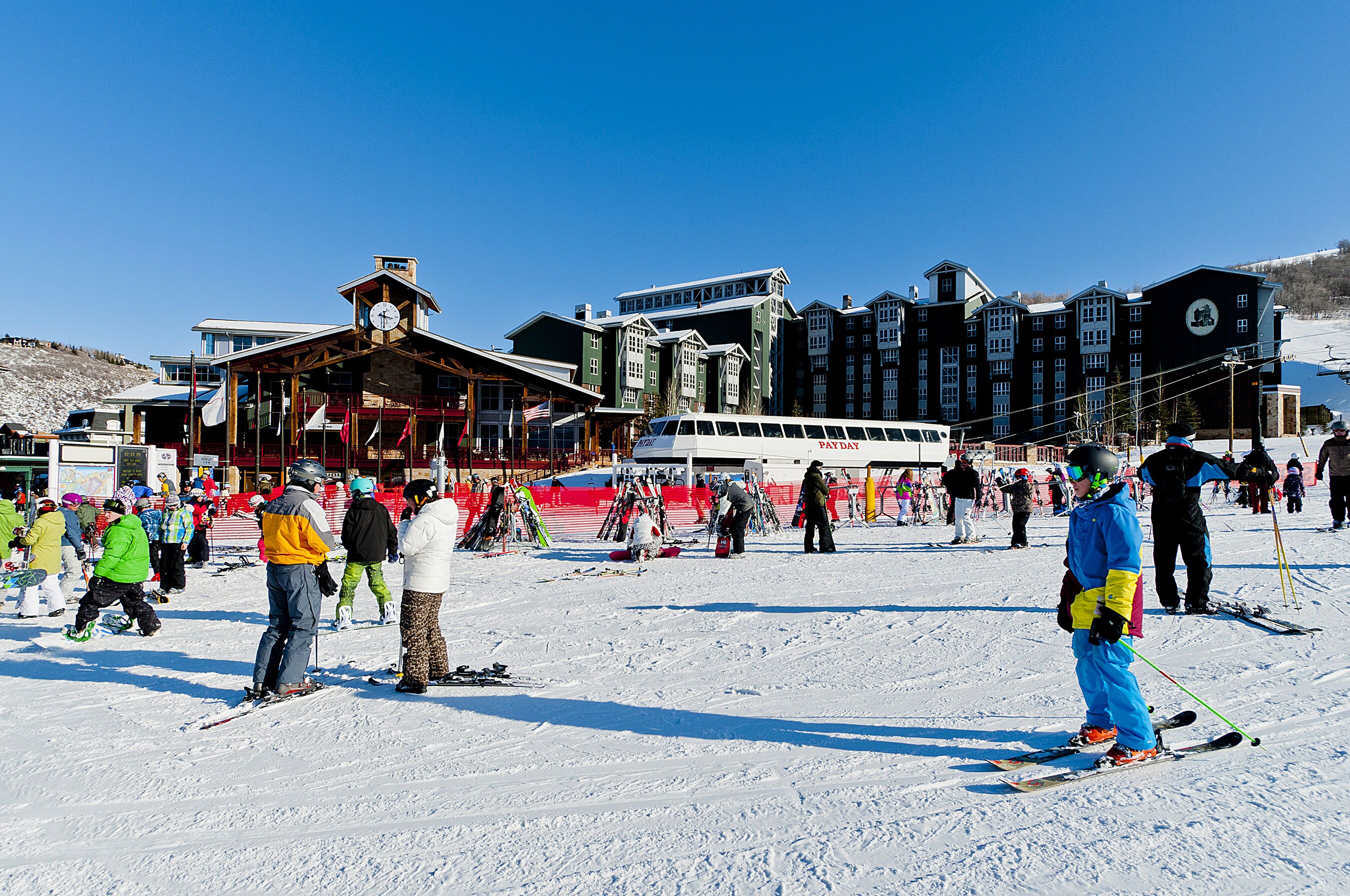A ski resort with a large building, ski lifts, and people skiing.
