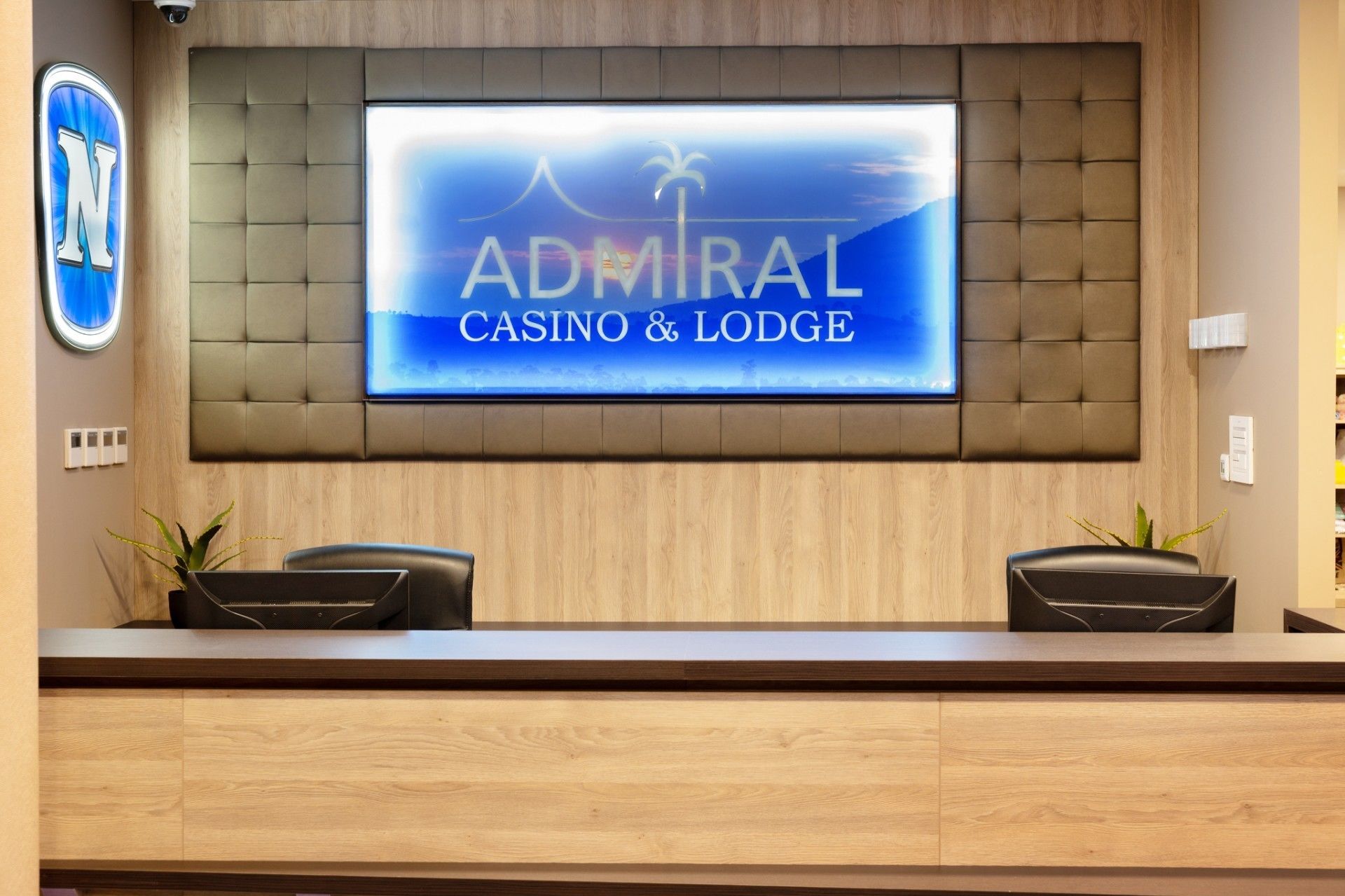 Un comptoir d’accueil avec une enseigne indiquant « Admiral Casino & Lodge ».