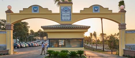 A large archway with a sign reading "CASINO ADIRAL SAN ROQUE" and a parking lot in the background.