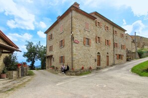 Un bâtiment en pierre doté de nombreuses fenêtres et d’une enseigne indiquant un lieu.