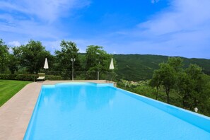 Une piscine rectangulaire à l’eau d’un bleu limpide, entourée d’une terrasse dallée.