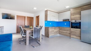 Une cuisine moderne avec des meubles en bois, un plan de travail bleu et un four encastré.