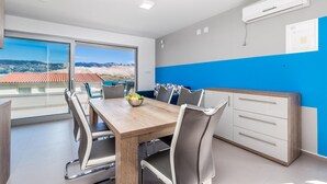 Une cuisine moderne avec une table en bois, des armoires blanches et un mur d’accent bleu.