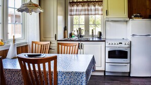 Une cuisine équipée d’une table à manger, de chaises, d’une cuisinière et d’un réfrigérateur.