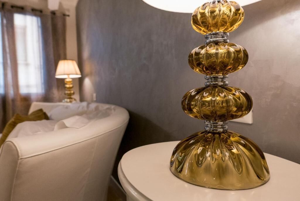 A bathroom with a white toilet, a white bathtub, and a gold decorative object on a white surface.